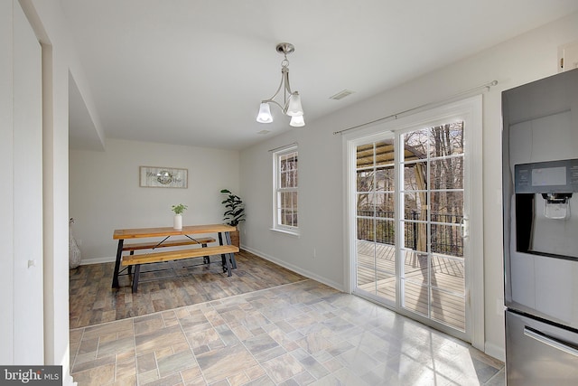 dining area featuring baseboards, visible vents, and a chandelier