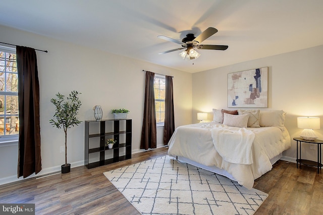 bedroom featuring a ceiling fan, baseboards, and wood finished floors