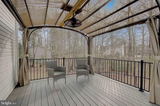 wooden deck featuring a ceiling fan and a pergola