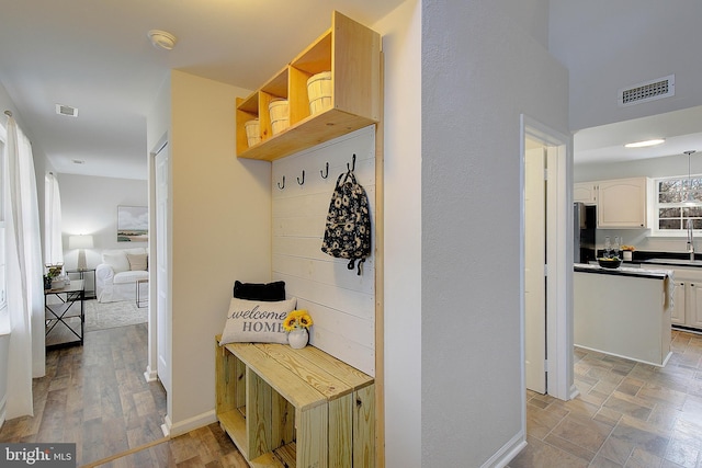 mudroom with a sink, visible vents, and baseboards