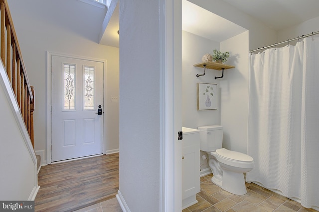 bathroom featuring baseboards, toilet, and wood finished floors