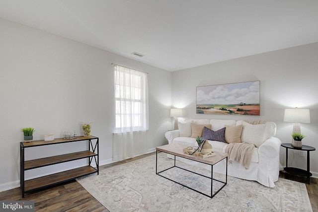 living area with visible vents, baseboards, and wood finished floors