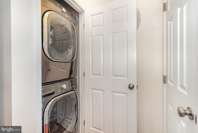 clothes washing area with laundry area and stacked washer and dryer