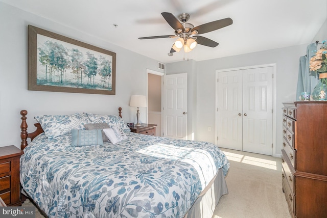 bedroom featuring visible vents, light carpet, a closet, and ceiling fan