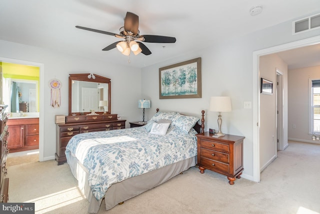 bedroom with a sink, baseboards, visible vents, and light carpet