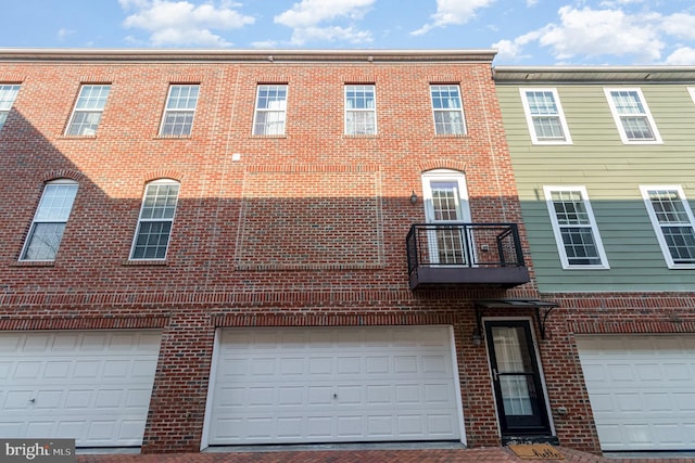 townhome / multi-family property with brick siding and a balcony