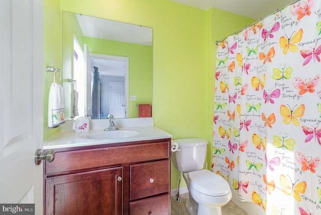 bathroom featuring toilet, vanity, and a shower with shower curtain