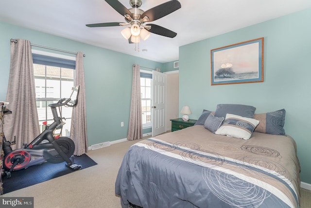 carpeted bedroom featuring multiple windows, baseboards, and visible vents