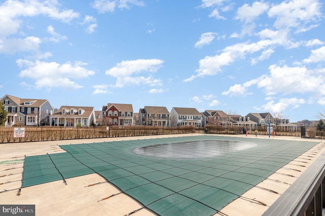 pool featuring a patio, fence, and a residential view