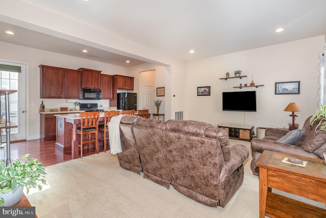 living room featuring recessed lighting and light carpet