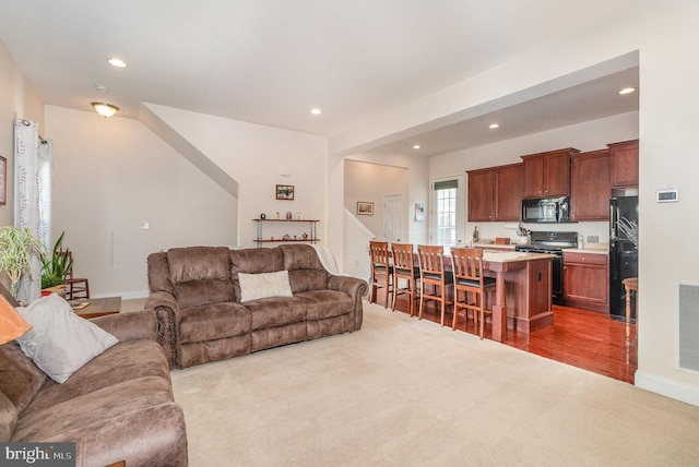 living room with recessed lighting, visible vents, carpet floors, and baseboards