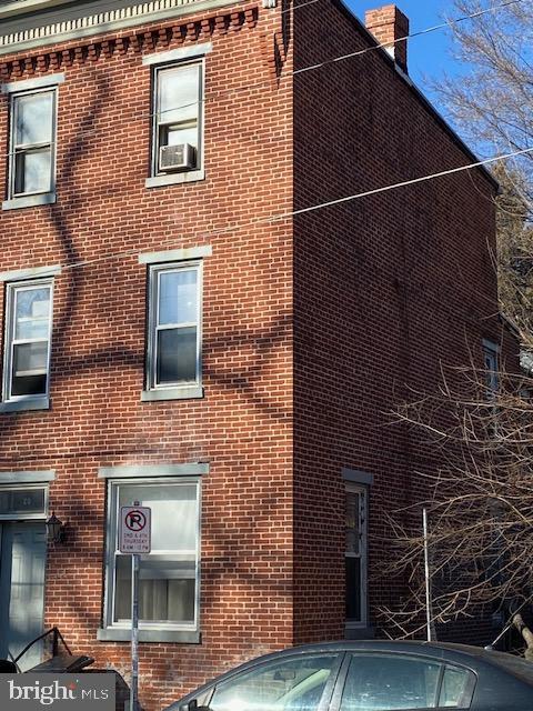 view of property exterior featuring brick siding and a chimney