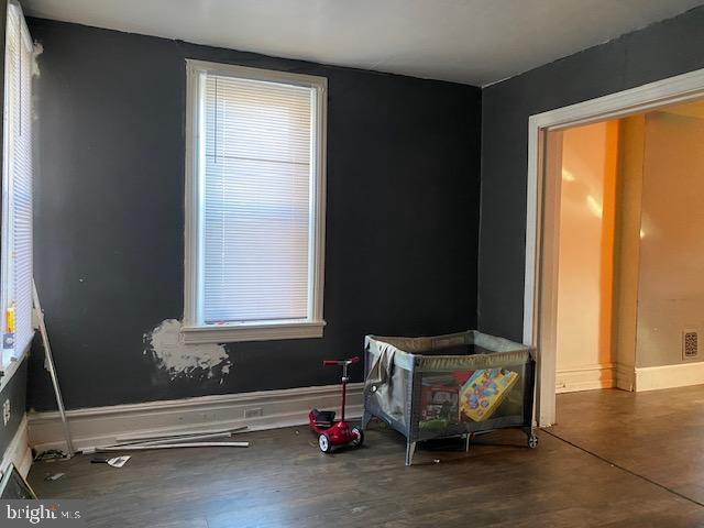 interior space with visible vents, baseboards, and wood finished floors