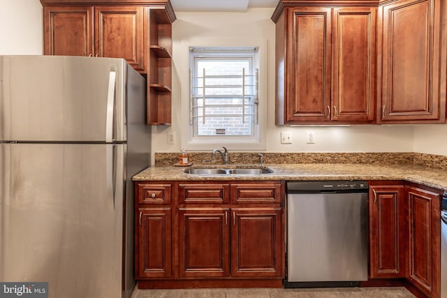 kitchen with light stone counters, appliances with stainless steel finishes, open shelves, and a sink