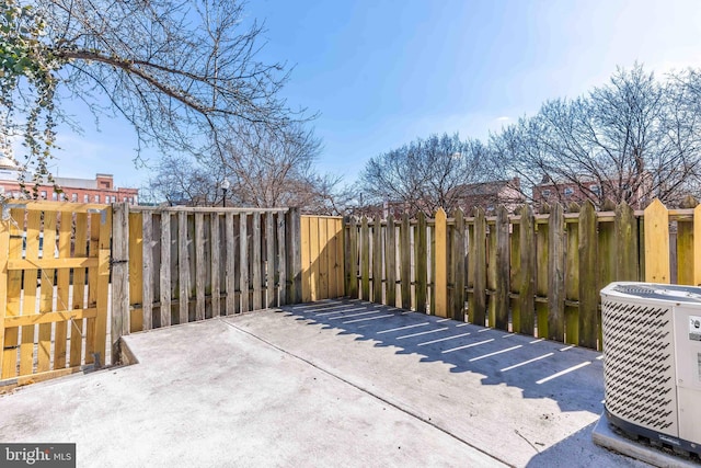 view of patio with central AC unit and fence