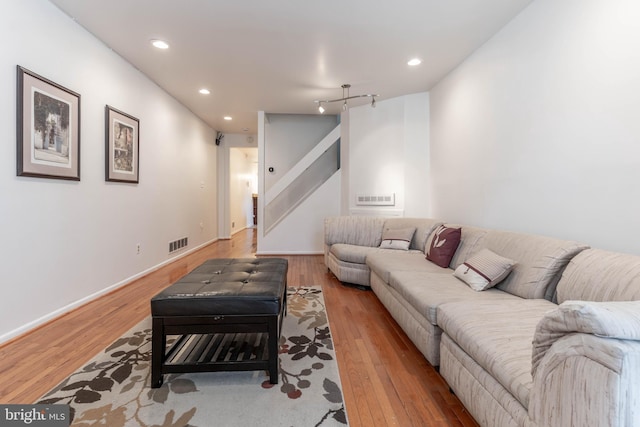 living area with light wood-style flooring, visible vents, and recessed lighting