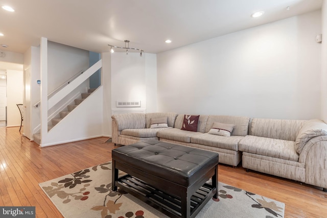 living area with recessed lighting, hardwood / wood-style floors, and stairs