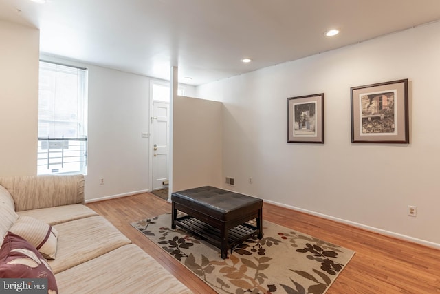 living area with visible vents, baseboards, a wealth of natural light, and wood finished floors