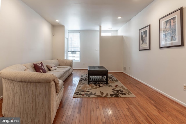 living area featuring recessed lighting, hardwood / wood-style flooring, and baseboards