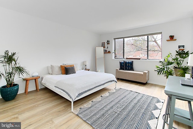 bedroom with light wood-style flooring and baseboards