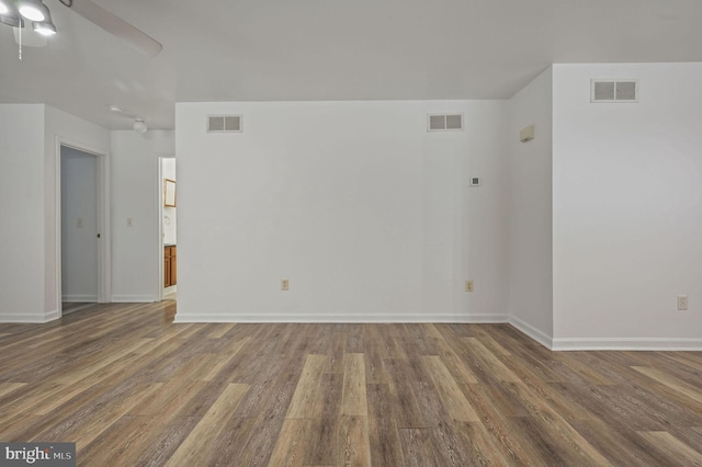 unfurnished room featuring wood finished floors, baseboards, and ceiling fan