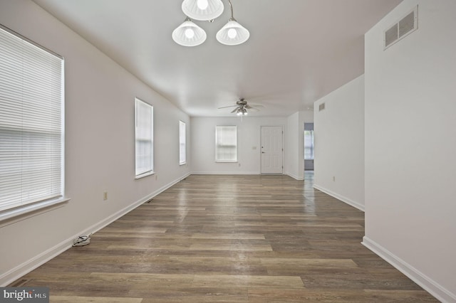 unfurnished living room featuring a ceiling fan, wood finished floors, and baseboards