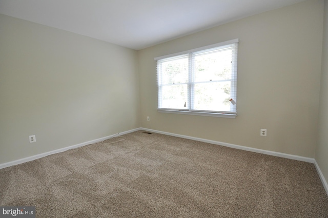 unfurnished room featuring baseboards and light colored carpet