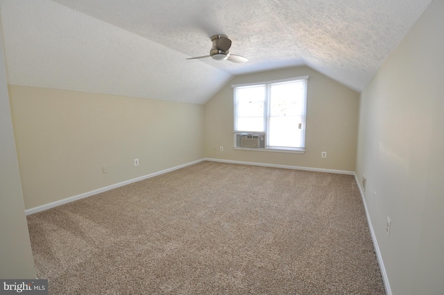 bonus room with a textured ceiling, lofted ceiling, cooling unit, carpet floors, and baseboards