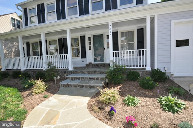 doorway to property featuring a garage and covered porch