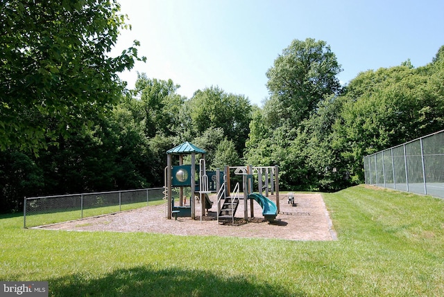 community jungle gym with fence and a yard