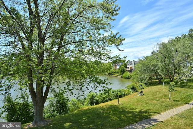 surrounding community featuring a water view and a lawn