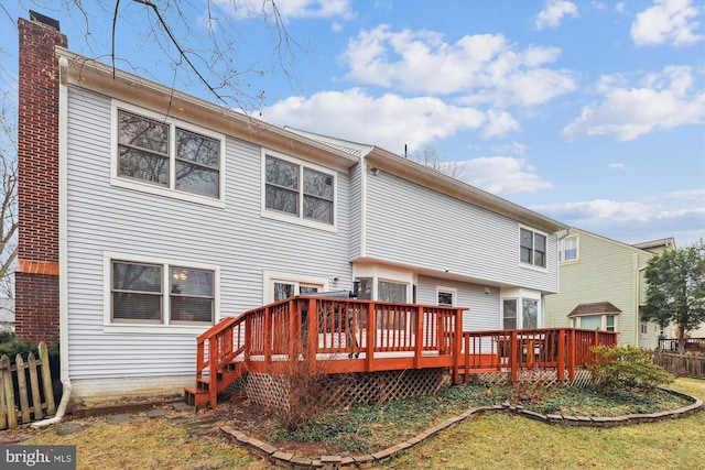 back of property with a deck, fence, and a chimney