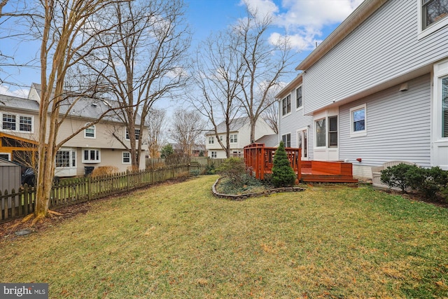 view of yard featuring a deck, fence, and a residential view