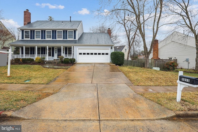 view of front of home with a garage, a chimney, fence, and a front yard