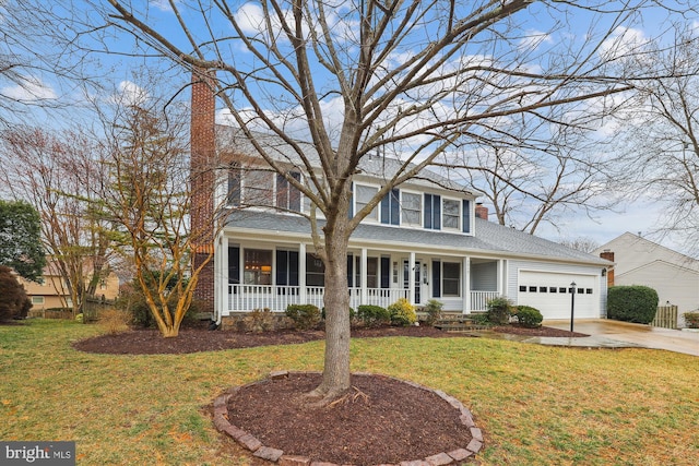 colonial house with a garage, concrete driveway, a front lawn, and a chimney