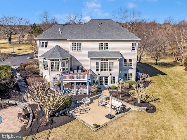 rear view of house featuring a shingled roof, a lawn, stairway, a patio area, and a deck