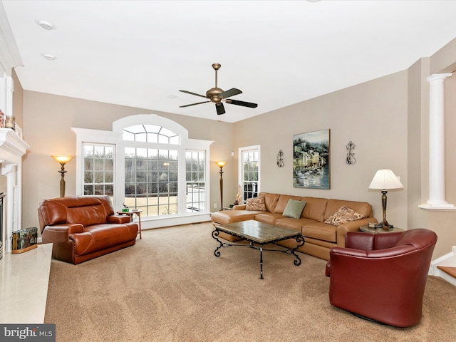 living room with a ceiling fan, a high end fireplace, carpet flooring, and ornate columns