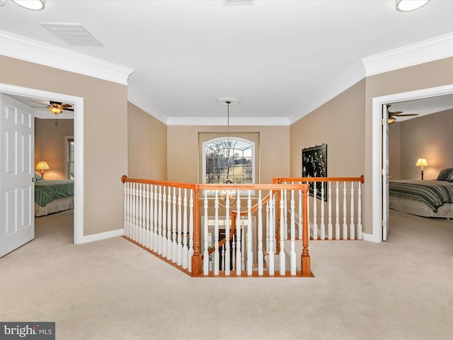 hall featuring carpet, baseboards, crown molding, and an upstairs landing