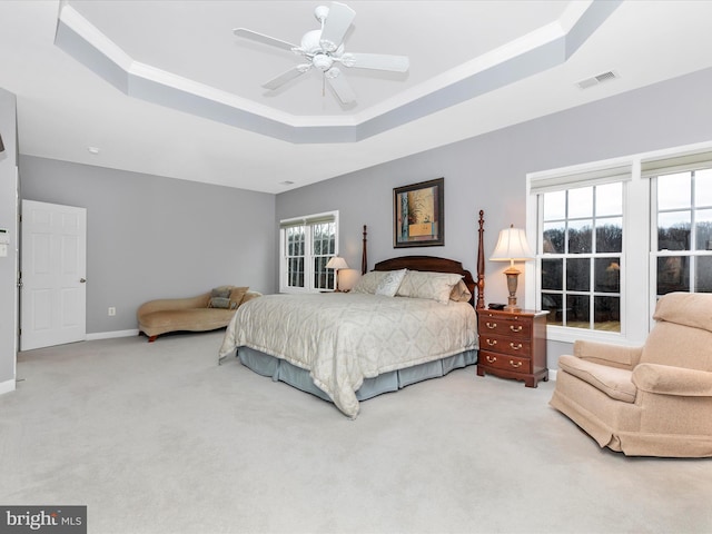 bedroom featuring a raised ceiling, visible vents, a ceiling fan, carpet flooring, and baseboards