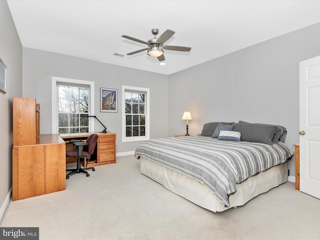 carpeted bedroom with a ceiling fan, visible vents, and baseboards