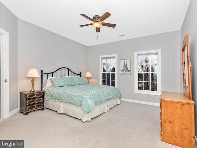 carpeted bedroom with a ceiling fan, visible vents, and baseboards