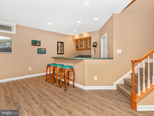 bar with recessed lighting, visible vents, stairway, light wood-type flooring, and baseboards