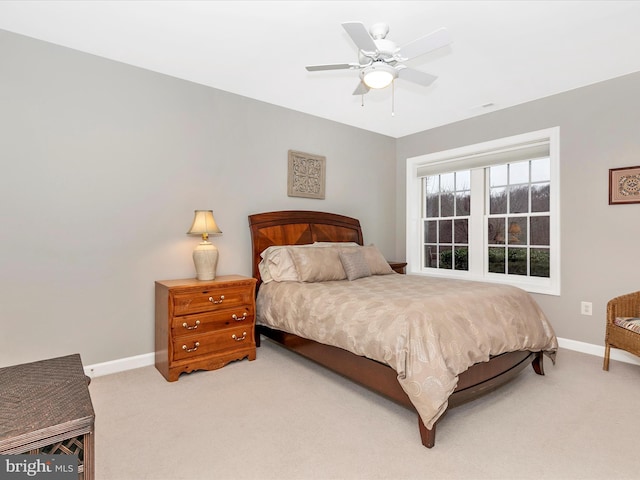 bedroom with a ceiling fan, light colored carpet, visible vents, and baseboards