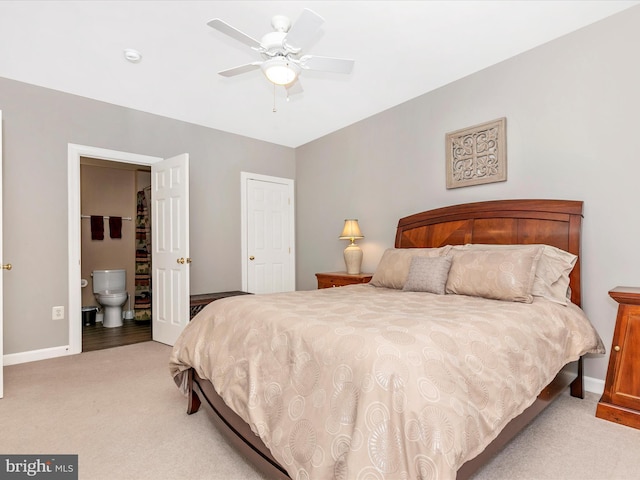 bedroom featuring light carpet, baseboards, and ensuite bathroom