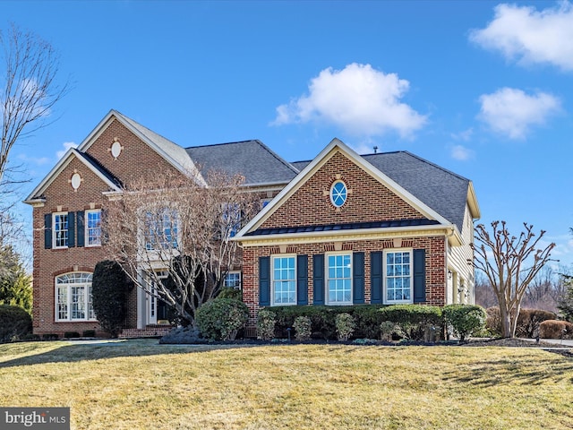 view of front of house with brick siding and a front yard