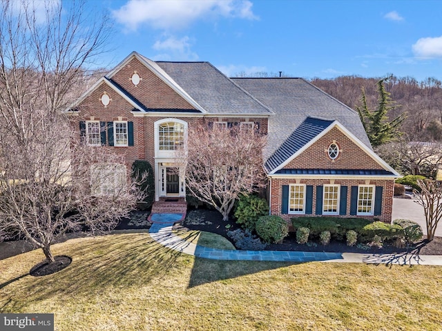 view of front of property with a front lawn and brick siding