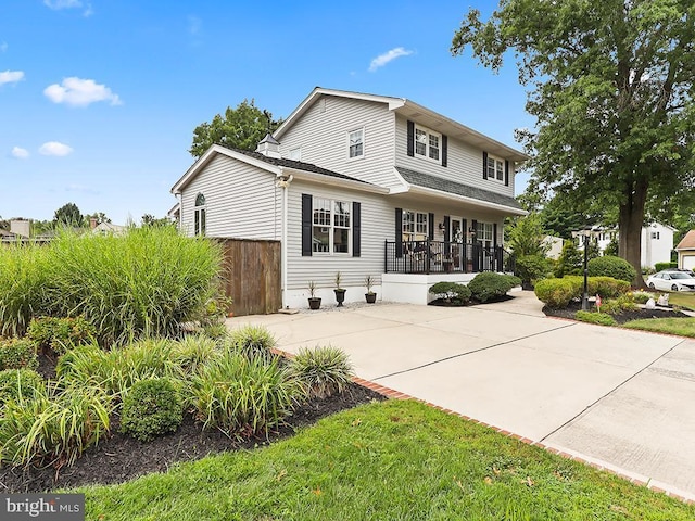 view of front of house featuring concrete driveway and fence