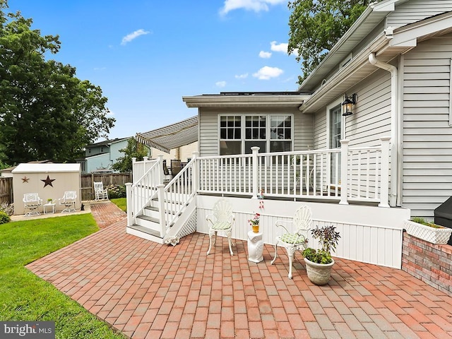 exterior space with a shed, fence, a deck, and an outdoor structure