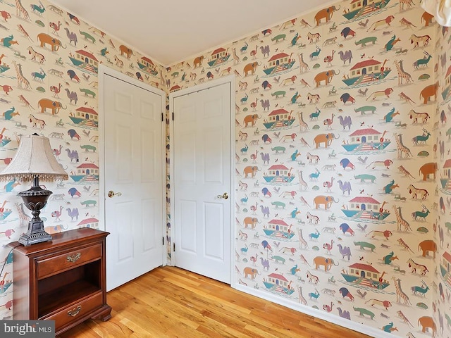 foyer entrance featuring wallpapered walls and light wood-style flooring