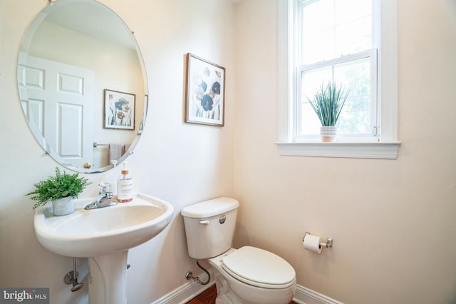 bathroom featuring baseboards and toilet